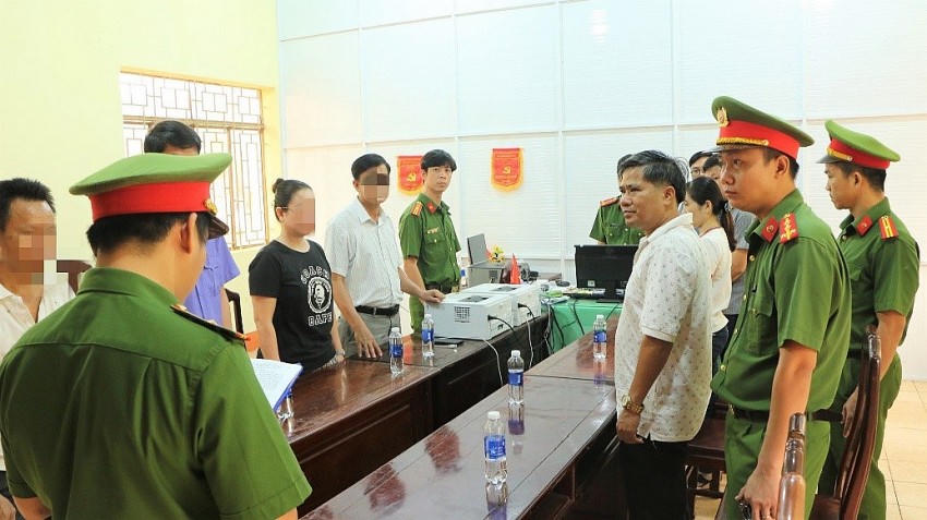 Công bố quyết định khởi tố bị can và lệnh bắt bị can để tạm giam đối với Nguyễn Hữu Hóa (áo trắng bên phải). Ảnh: Công an Bình Phước.