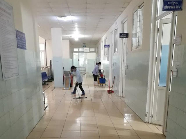 Các nhân viên bệnh viện đang tiến hành lau chùi sàn nhà, dọn dẹp vệ sinh.