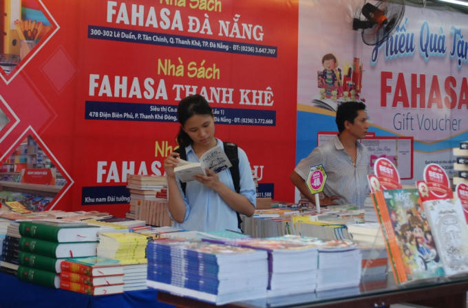 Một bạn trẻ say mê đọc sách trước khi đưa ra lựa chọn mua sách.
