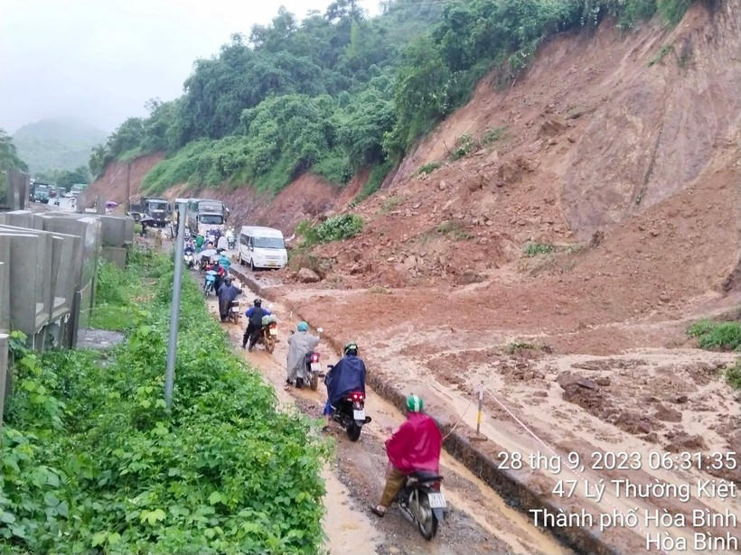 Các phương tiện di chuyển rất khó khăn trên đoạn đường sạt lở.