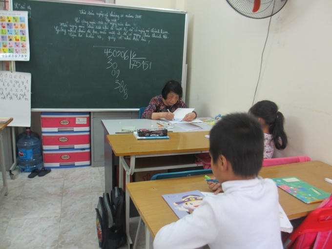 Mặc dù đang là giờ ra chơi nhưng cô Côi vẫn tranh thủ chấm bài cho học sinh (Ảnh: Mẫn Nhi)