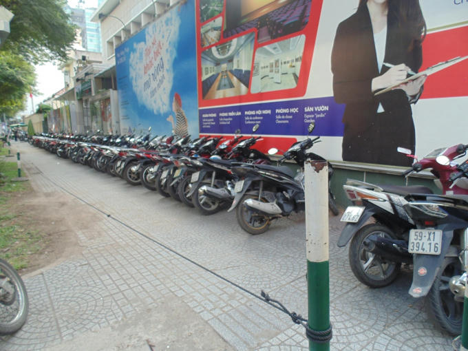 Vỉa hè ngang nhiên bị rào lại làm bãi giữ xe trên đường Lê Thánh Tôn.