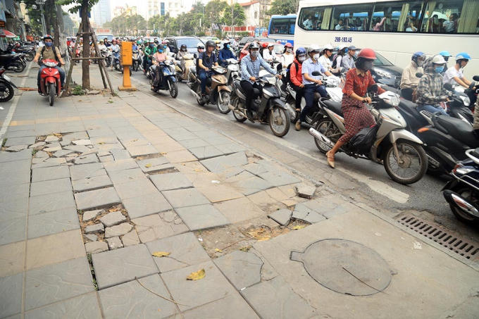 Vào giờ cao điểm nhiều xe máy thường xuyên leo lên vỉa hè là một phần nguyên nhân dẫn đến hiện tượng bong tróc