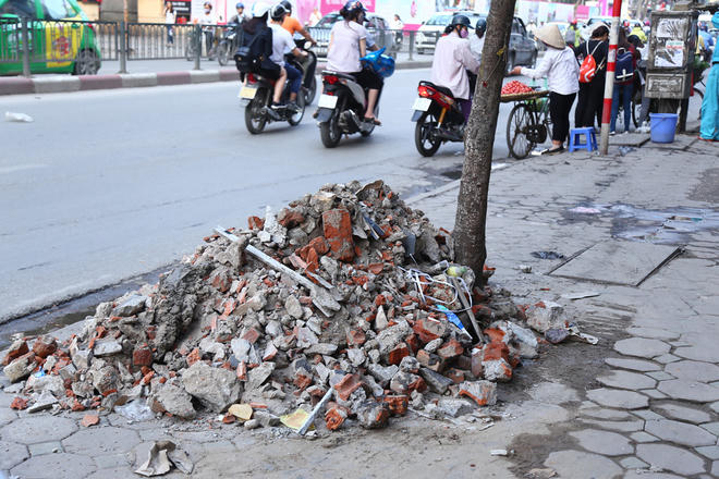 Một hộ dân trên phố Chùa Bộc (Đống Đa) cho biết, sau khi lực lượng chức năng đi phá dỡ các phần lấn chiếm vỉa hè, gia đình đã thu dọn và đổ phế thải ra cạnh gốc cây nhưng mấy ngày trôi qua vẫn chưa có người đi thu dọn.