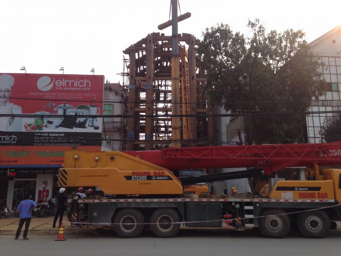 Ngôi nhà gỗ 5 tầng đang được hình thành, luôn có những xe cẩu loại lớn túc trực xung quanh, mỗi khi cần cẩu hoạt động, lái xe thường căng dây và chóp nón bằng nhựa để cảnh báo người đi đường.
