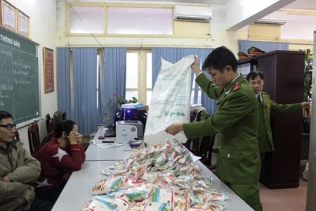 Đối tượng Nụ áo đỏ cùng tang vật bị thu giữ trong quá trình tiêu thụ tại cơ quan công an. (ảnh Đông Bắc)