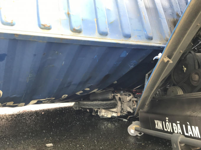 Chiếc xe máy mặc kẹt dưới thùng container.