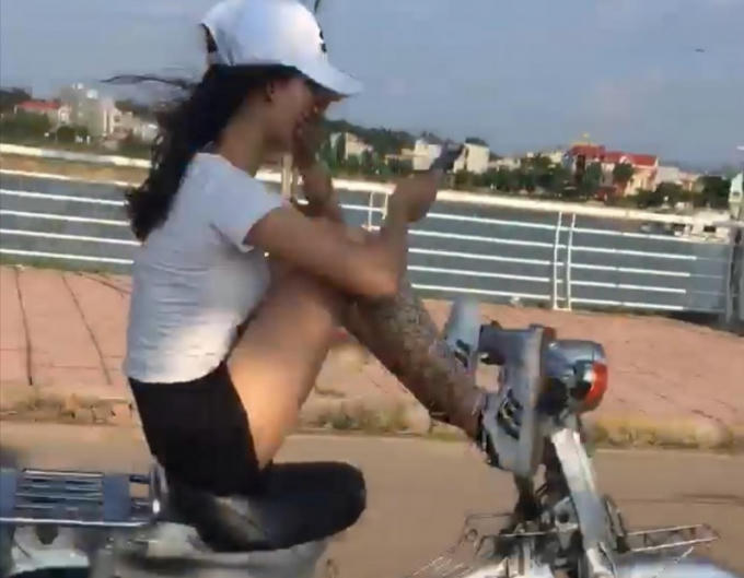 Cô gái dùng chân lái xe máy gây bức xúc dư luận.