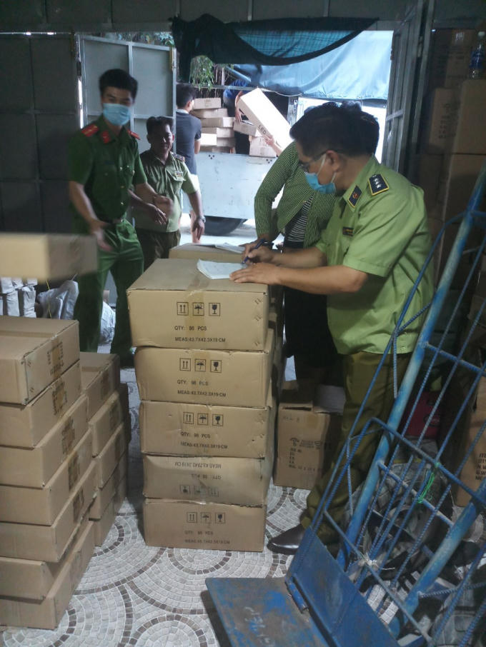 Lực lượng chức năng kiểm tra, thu giữ hàng hóa vi phạm. (Ảnh Cục QLTT Vĩnh Long)