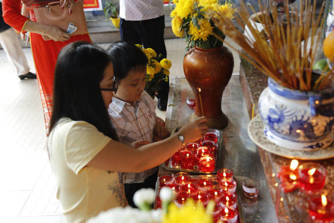 Chị hướng dẫn em đốt đèn cầy.