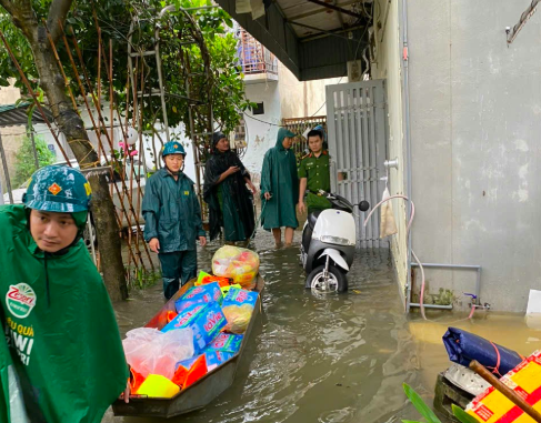 Lực lượng chức năng Công an phường Kiến Hưng hỗ trợ nhu yếu phẩm cần thiết đến các hộ dân bị ngập sâu sau trận mưa lớn, kéo dài.