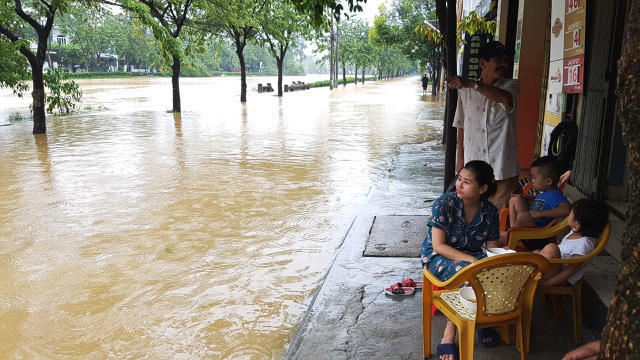 Một gia đình cho con ăn cơm trưa và xem lũ về
