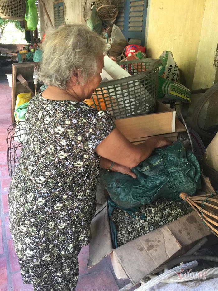 Bà Bông gom hạt vào những bao lớn để bán.