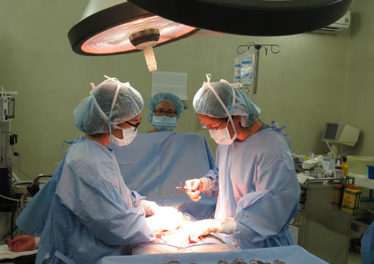 Các bác sĩ đang vui vẻ khâu nốt những mũi khâu cuối cùng sau một ca mổ sinh "mẹ tròn con vuông"