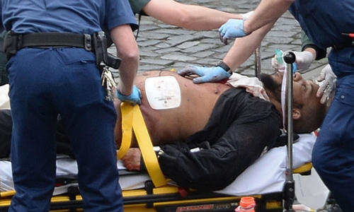 Khalid Masood được cấp cứu bên ngoài quốc hội trong khi cảnh sát có vũ trang đứng canh. Ảnh: PA