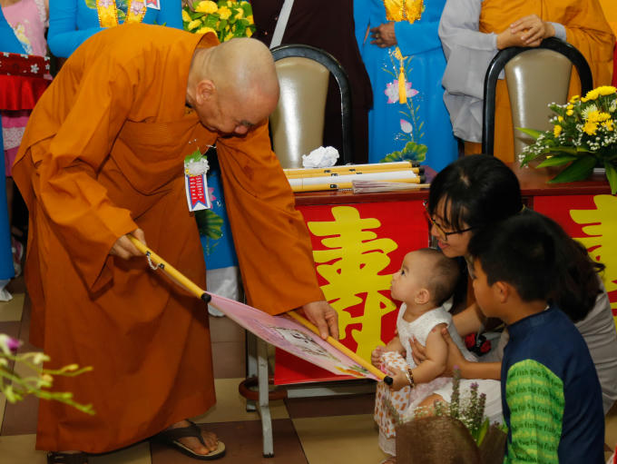 Những em bé được cha mẹ đưa đến chùa.