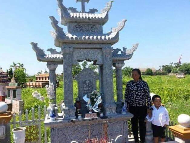 Bà Nguyệt và cháu nội bên cạnh ngôi mộ tập thể chôn hàng ngàn xác thai nhi xấu số sau 6 năm thu gom.