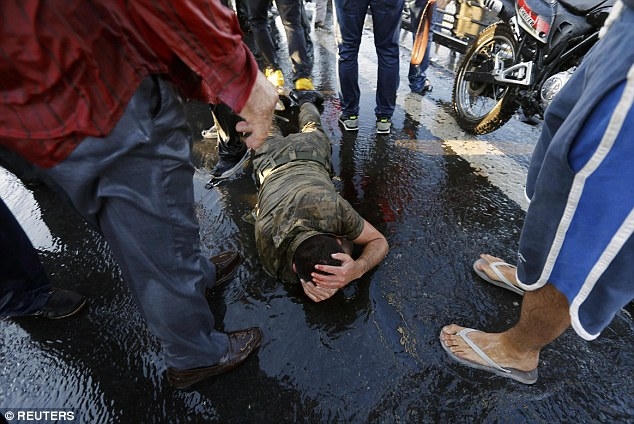 Một binh sỹ đảo chính bị người dân tức giận đánh trọng thương. (Ảnh: Reuters)