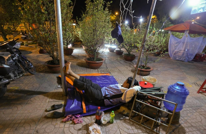 Tại công viên Gia Định, những người trồng mai ở vùng An Phú Đông (quận 12) đã mang hoa xếp thành hàng trên vỉa hè. Những chiếc lều, màn, tấm bạt… được trải ra. "Ở khu này rất nhiều hoa đủ loại nên bọn trộm hay ăn cắp, nhất là mấy cây nhỏ. Tôi đêm nào cũng phải thức ít nhất 4 tiếng trông chừng", anh Nguyễn Ngọc Long (42 tuổi, quận 12) nói.