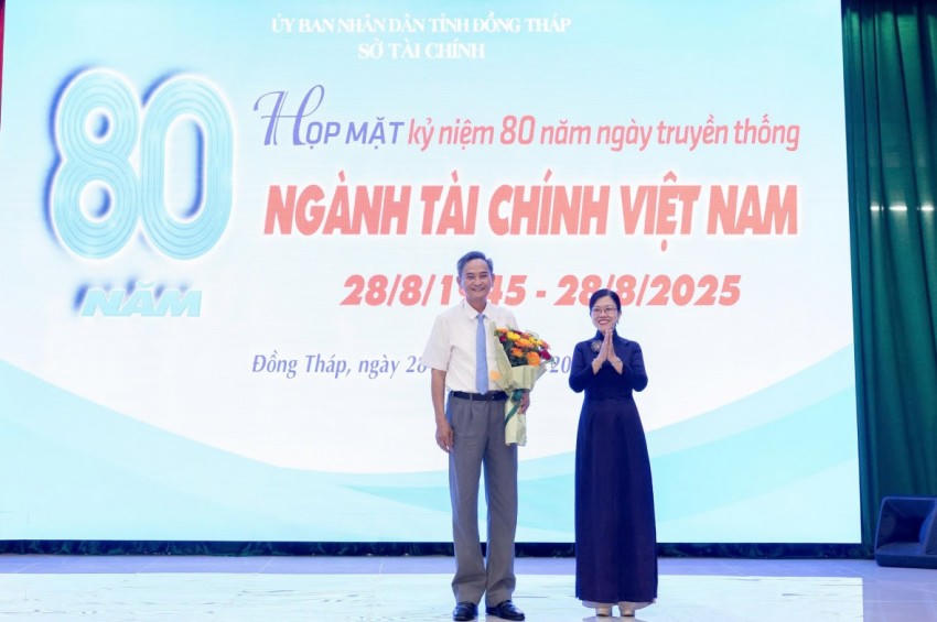 Giám đốc Sở Tài chính Nguyễn Kim Tuyến tặng hoa cho ông Nguyễn Hữu Chí - Nguyên Thứ trưởng Bộ Tài chính. Ảnh: Xuân Uyên