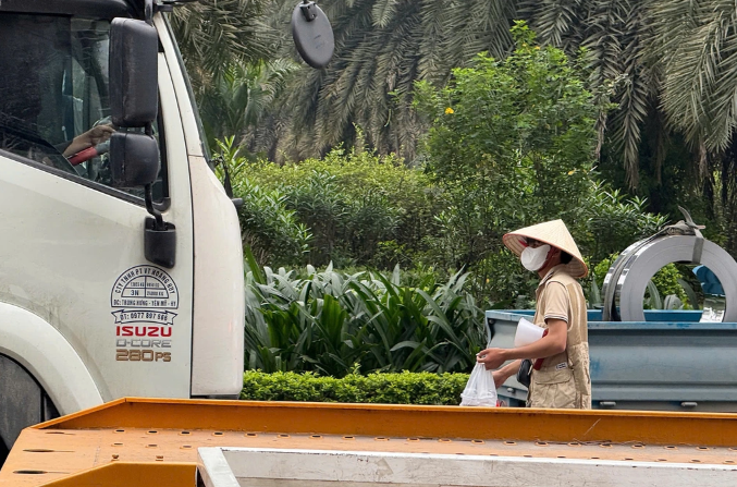 Lợi dụng việc các xe tải chờ đèn đỏ, nhóm người bán cà phê, đồ ăn đi ra mời chào gây mất an toàn giao thông.