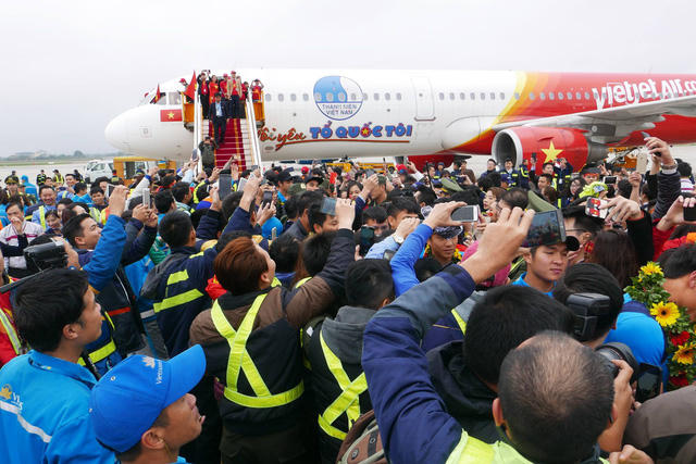 Các tuyển thủ U23 Việt Nam lần lượt bước ra khỏi Chuyên cơ trong sự chào đón nồng nhiệt của người hâm mộ. ( Ảnh Quý Đoàn )