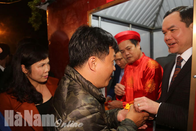 Bí thư Tỉnh ủy Hà Nam Nguyễn Đình Khang phát lương cho du khách về dự lễ hội đền Trần Thương năm 2018.