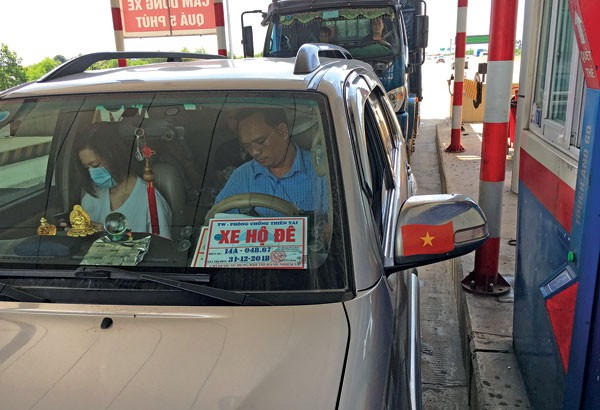 Xe BKS 14A - 048.67 gắn phù hiệu "xe hộ đê" qua Trạm thu phí cao tốc Hà Nội - Hải Phòng vào lúc 9h50 sáng 7/9. Tuy nhiên, Cục Ứng phó sự cố và khắc phục hậu quả thiên tai khẳng định không cấp phù hiệu "xe hộ đê" cho xe này - Ảnh: Đình Quang