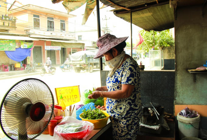 Một người dân buôn bán gần đường phải bịt khăn để tránh bụi. Quán ăn thì ế ẩm vì bụi quá nhiều, không ai dám ăn.