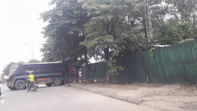 Xe tải ra vào chở vật liệu xây dựng.