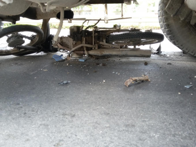 Chiếc xe máy lọt dưới gầm xe bồn.