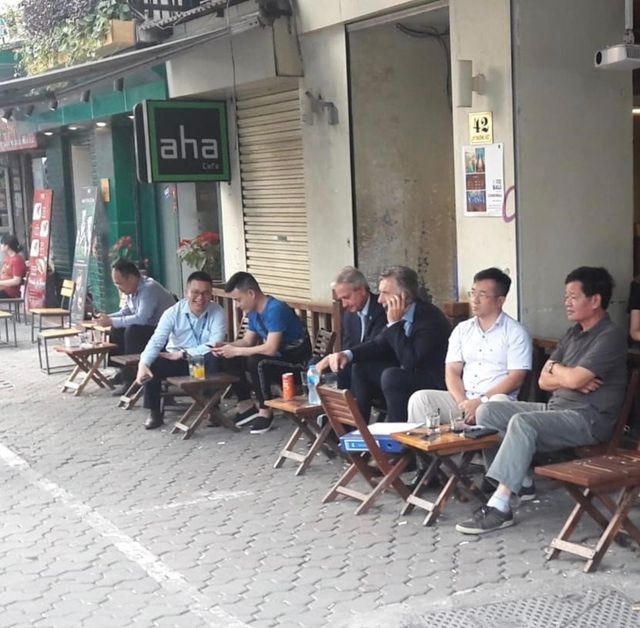 Tổng thống Argentina ngồi tại một quán cà phê vỉa hè tại Hà Nội. (Ảnh: Clarin)