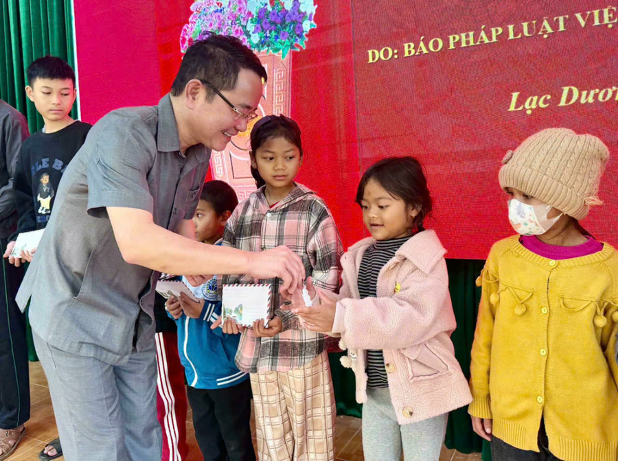 TS Vũ Hoài Nam - Tổng Biên tập Báo Pháp luật Việt Nam trao quà cho các em nhỏ.