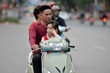 Một gia đình cả ba thành viên không đội mũ bảo hiểm.