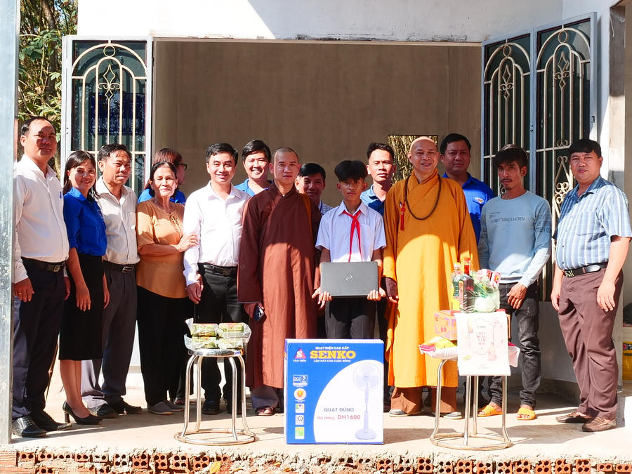 Các đơn vị tài trợ cùng chính quyền địa phương chụp hình lưu niệm cùng gia đình em Nguyễn Huỳnh Quốc Bảo tại lễ bàn giao Nhà Khăn quàng đỏ.