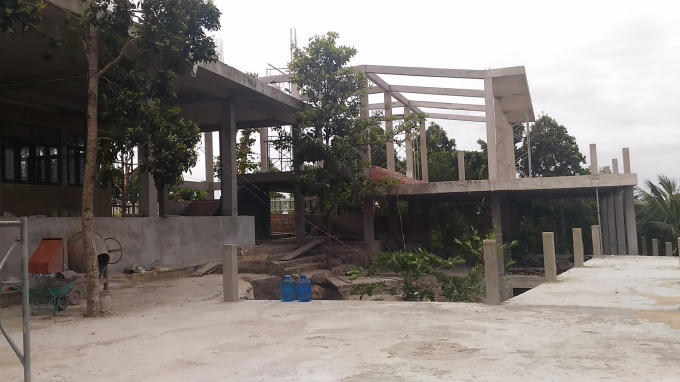 Một công trình nhà nhiều tầng kiên cố mọc lên gần đỉnh núi.