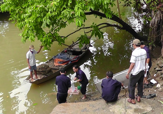 Thi thể nạn nhân được trục vớt lên bờ.
