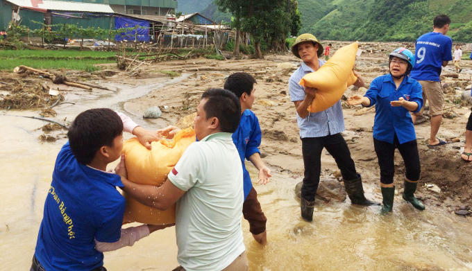 Đường đi gặp nhiều con suối, thanh niên tình nguyện đứng làm cầu vận chuyển lương thực, đẩy nhanh tiến độ tiếp tế.