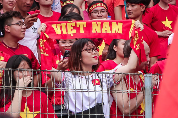 Một fan nữ giơ cao tấm băng rôn với dòng chữ "Việt Nam".