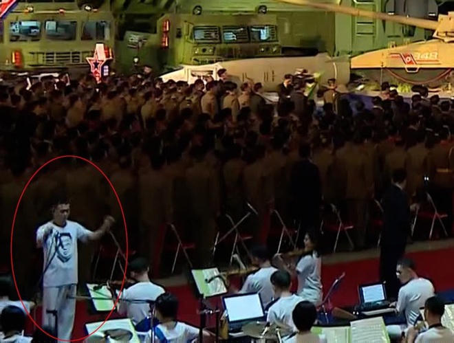 Chỉ huy dàn nhạc mặc áo in hình nhà lãnh đạo Kim Jong-un tại triển lãm quốc phòng hôm 11/10 (Ảnh: Yonhap).