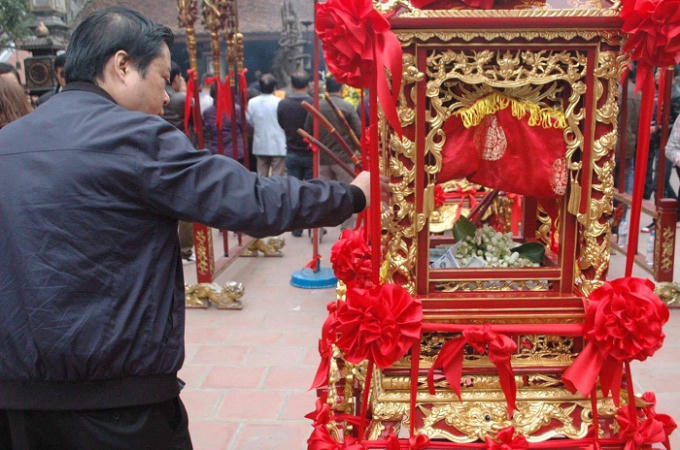 Du khách thản nhiên thả tiền lẻ vào kiệu ấn.