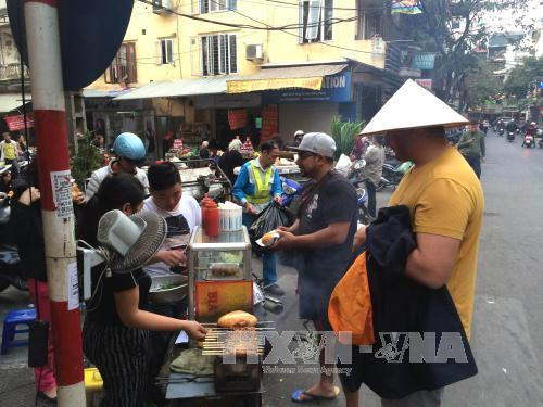Những món ăn dân dã trên hè phố Hàng Bè thu hút không chỉ người dân mà còn cả những du khách nước ngoài muốn khám phá Tết và món ăn Việt. Ảnh: Hải Anh/TTXVN