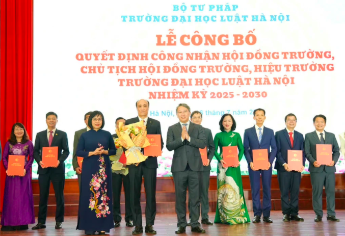 Bộ trưởng Nguyễn Hải Ninh và Thứ trưởng Tư pháp Đặng Hoàng Oanh tặng hoa và trao quyết định cho PGS.TS Tô Văn Hòa, tân Hiệu trưởng Trường Đại học Luật Hà Nội và các thành viên hội đồng trường (Ảnh: Phương Mai).