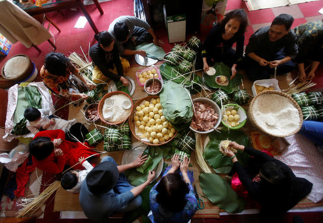Gói bánh chưng cũng là một phong tục truyền thống của người dân Việt Nam mỗi dịp Tết đến, xuân về. Đây cũng là dịp để cả gia đình quây quần bên nhau và ôn lại một năm cũ đã qua (Ảnh: Reuters)