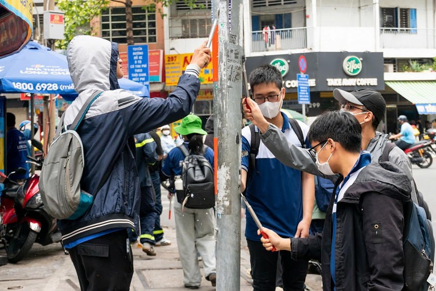 Các sinh viên xuống đường bóc xóa quảng cáo sai quy định.