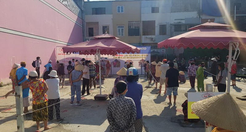 Người dân nghèo xếp hàng, giữ đúng khoảng cách đến lấy gạo.