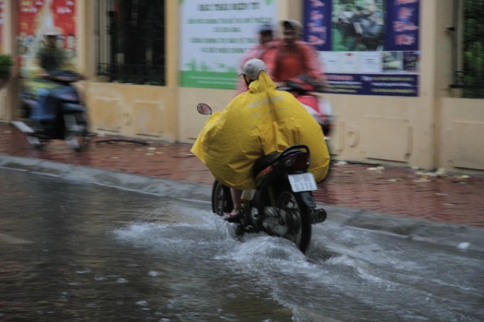 Người tham gia giao thông tránh khu vực nước sâu đi lên cả vỉa hè.