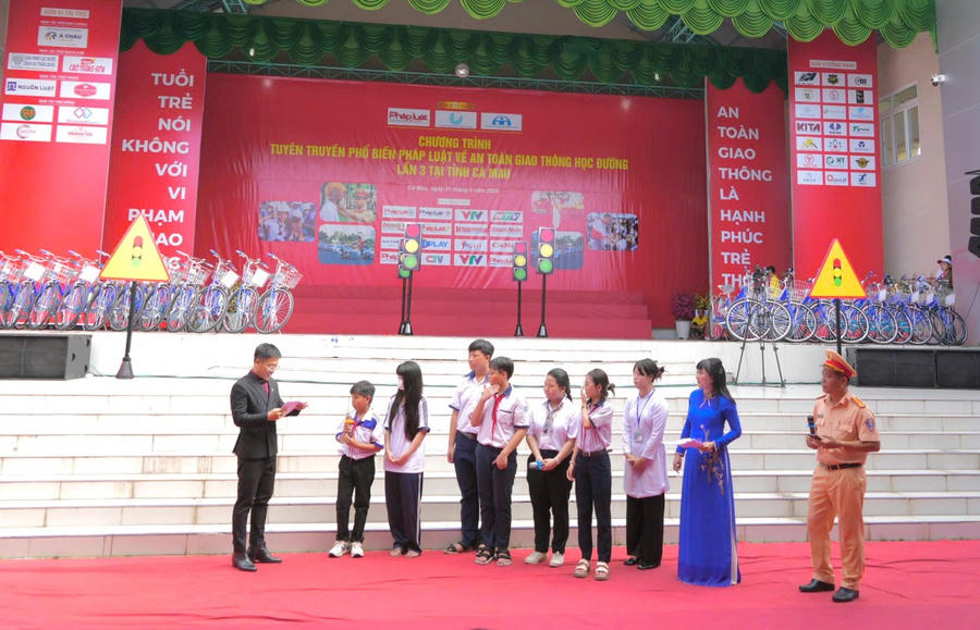 Cảnh sát giao thông Công an Cà Mau, tuyên truyền, phổ biến pháp luật về an toàn giao thông và thực hiện các tình huống thực tế về trật tự an toàn giao thông, hướng dẫn đội mũ bảo hiểm đúng cách.