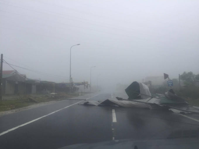 Gió giật mạnh giữ dội, nhiều mái nhà hai bên Quốc lộ 1A đoạn qua Kỳ Anh, Hà Tĩnh đã bị tốc mái, bay xuống đường.