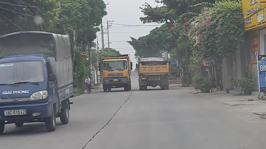 Nhiều xe tải chạy tung hoành trong khu đông dân cư khiến các em học sinh đi nép vào bên đường.